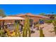 Landscaped backyard with covered hot tub, cactus garden, and outdoor seating at 1702 W Amberwood Dr, Phoenix, AZ 85045