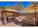 Backyard features hot tub under gazebo and comfortable cushioned sofa at 1702 W Amberwood Dr, Phoenix, AZ 85045