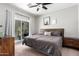 Bedroom with a queen sized bed, wooden nightstands, and a sliding glass door to the patio at 1702 W Amberwood Dr, Phoenix, AZ 85045
