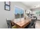 Dining area with a rustic wooden table and comfortable seating adjacent to the bright kitchen at 1702 W Amberwood Dr, Phoenix, AZ 85045