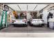 Well-decorated two-car garage featuring two modern sports cars at 1702 W Amberwood Dr, Phoenix, AZ 85045