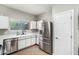Kitchen area features stainless steel refrigerator, white countertops, and a window with natural light at 1702 W Amberwood Dr, Phoenix, AZ 85045