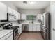 A modern kitchen featuring stainless steel appliances, white cabinets, and a window over the sink at 1702 W Amberwood Dr, Phoenix, AZ 85045
