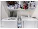 Clean laundry room with white washer and dryer, storage shelves and cleaning supplies at 1702 W Amberwood Dr, Phoenix, AZ 85045