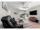 Comfortable living room with a plush reclining sofa, ceiling fan, and access to the patio at 1702 W Amberwood Dr, Phoenix, AZ 85045