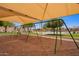 Enjoy the community playground swingset underneath a sunshade and desert landscaping at 1702 W Amberwood Dr, Phoenix, AZ 85045