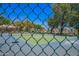 Tennis court view through a green chain-link fence with blue surface at 1702 W Amberwood Dr, Phoenix, AZ 85045