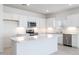 Bright kitchen featuring white cabinetry, stainless steel appliances, quartz countertops and a center island at 17743 W Onyx Ave, Waddell, AZ 85355