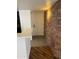 Inviting entryway with brick accent wall, light fixture, and durable tile and wood floors at 1800 W Elliot Rd # 107, Chandler, AZ 85224