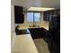 Well-lit kitchen featuring sleek black appliances, white countertops, and stylish tiled backsplash at 1800 W Elliot Rd # 107, Chandler, AZ 85224
