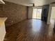 Spacious living room with hardwood flooring, fireplace, and a brick accent wall at 1800 W Elliot Rd # 107, Chandler, AZ 85224