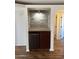 Wet bar nook with mini-fridge, wooden accent wall, and overhead light fixture at 1800 W Elliot Rd # 107, Chandler, AZ 85224