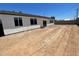 Expansive backyard featuring multiple windows providing ample natural light and block fence, perfect for outdoor activities at 1835 E Burgess Ln, Phoenix, AZ 85042
