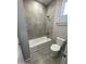 Bathroom with tiled bathtub, shower and a toilet adjacent to the towel rack at 1835 E Burgess Ln, Phoenix, AZ 85042