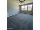 Bright bedroom featuring three large windows that flood the room with natural light and plush carpeting at 1835 E Burgess Ln, Phoenix, AZ 85042