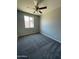 A carpeted bedroom with a ceiling fan and a window that lets in plenty of natural light at 1835 E Burgess Ln, Phoenix, AZ 85042