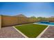 A private fenced in backyard with an artificial turf lawn and desert landscaping at 20499 W Alsap Rd, Buckeye, AZ 85396