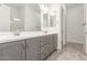 Bathroom features dual sinks, gray cabinets, tile floor, and modern lighting at 20499 W Alsap Rd, Buckeye, AZ 85396