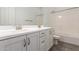 Bright bathroom with double sinks, white cabinets, and wood-look tile floor at 20499 W Alsap Rd, Buckeye, AZ 85396