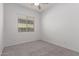 This carpeted bedroom is bright with one window, and neutral paint at 20499 W Alsap Rd, Buckeye, AZ 85396