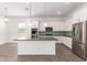 Open kitchen featuring stainless steel appliances, a spacious island, white cabinets and views to dining area at 20499 W Alsap Rd, Buckeye, AZ 85396