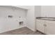 A laundry room with new gray floors, and a sink and cabinets, ready for a washer and dryer at 20499 W Alsap Rd, Buckeye, AZ 85396
