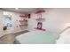 Bedroom with view to second room, bright shelves, wood look flooring and vibrant decor at 2103 N Silverton St, Mesa, AZ 85203