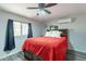 Cozy bedroom with a ceiling fan, a red comforter and gray walls, creating a relaxing space at 2103 N Silverton St, Mesa, AZ 85203