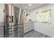 Bright kitchen with stainless steel refrigerator, granite counters, and window with lemon print curtains at 2103 N Silverton St, Mesa, AZ 85203
