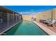 Backyard pool area featuring a tanning shelf, cabana, table and chairs, and privacy wall at 2103 N Silverton St, Mesa, AZ 85203