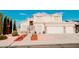 Beautiful two-story home showcasing a well-manicured lawn, lovely landscaping, and a charming red windmill at 2130 N Cypress Point N Way, Casa Grande, AZ 85122