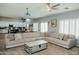Bright and airy living room with projector, neutral walls, ceiling fan, and ample seating at 2130 N Cypress Point N Way, Casa Grande, AZ 85122