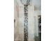 Close up of the river rock accent strip in a shower with shower head and shampoo nook at 2130 N Cypress Point N Way, Casa Grande, AZ 85122