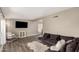 Comfortable living room with dark couch, light wood flooring, and bright natural light at 2210 E Birchwood Ave, Mesa, AZ 85204