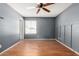 This bedroom features gray walls, wood floors, a ceiling fan, and a window with natural light at 2215 W Straford Dr, Chandler, AZ 85224