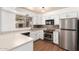 Updated kitchen features stainless steel appliances, ample counter space, white cabinets, and wood-look flooring at 2215 W Straford Dr, Chandler, AZ 85224