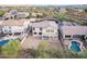 High aerial showcasing backyard, covered patio, and proximity to neighboring pools in a desert community at 2336 W Laredo Ln, Phoenix, AZ 85085