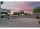 View of the backyard and patio with a beautiful pink and orange sky at sunset at 2336 W Laredo Ln, Phoenix, AZ 85085
