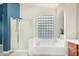 Bright bathroom featuring glass block window, bathtub, and shower at 2336 W Laredo Ln, Phoenix, AZ 85085