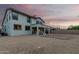 Back exterior of home with covered patio, gravel-filled yard area and stunning sunset sky at 2336 W Laredo Ln, Phoenix, AZ 85085