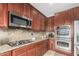 Well-equipped kitchen featuring stainless steel appliances, granite counters, and rich wood cabinetry at 2336 W Laredo Ln, Phoenix, AZ 85085