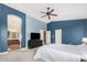 Comfortable main bedroom featuring blue walls, ceiling fan, and en-suite bathroom access at 2336 W Laredo Ln, Phoenix, AZ 85085