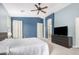 Spacious main bedroom featuring blue accent wall, ceiling fan, and en-suite bathroom access at 2336 W Laredo Ln, Phoenix, AZ 85085