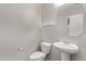 Powder room featuring a pedestal sink, toilet, and minimalist decor at 2547 E Vermont Dr, Gilbert, AZ 85295