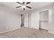 Bedroom featuring carpet flooring, ceiling fan, closet, and white door with access to the bathroom at 2547 E Vermont Dr, Gilbert, AZ 85295