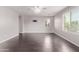 Bedroom with wood floors, ceiling fan, bright windows and mounted TV at 2547 E Vermont Dr, Gilbert, AZ 85295