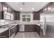 Well-equipped kitchen with stainless steel appliances, dark wood cabinets, and a window overlooking the backyard at 2547 E Vermont Dr, Gilbert, AZ 85295