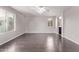 Spacious living room featuring wood floors, large windows and a ceiling fan with decorative lighting at 2547 E Vermont Dr, Gilbert, AZ 85295