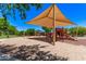 Community playground with shade structure and various play elements on a sand base at 2547 E Vermont Dr, Gilbert, AZ 85295