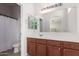 Bright bathroom featuring a large mirror and wooden cabinets at 336 N 168Th Dr, Goodyear, AZ 85338